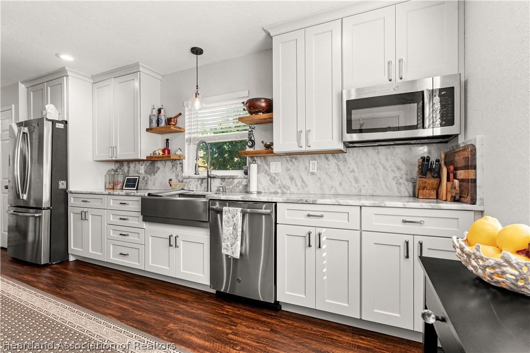 237 Wild Duck Point Lorida, FL 33857 - Photo 20 of 39 a kitchen with white cabinets and stainless steel appliances