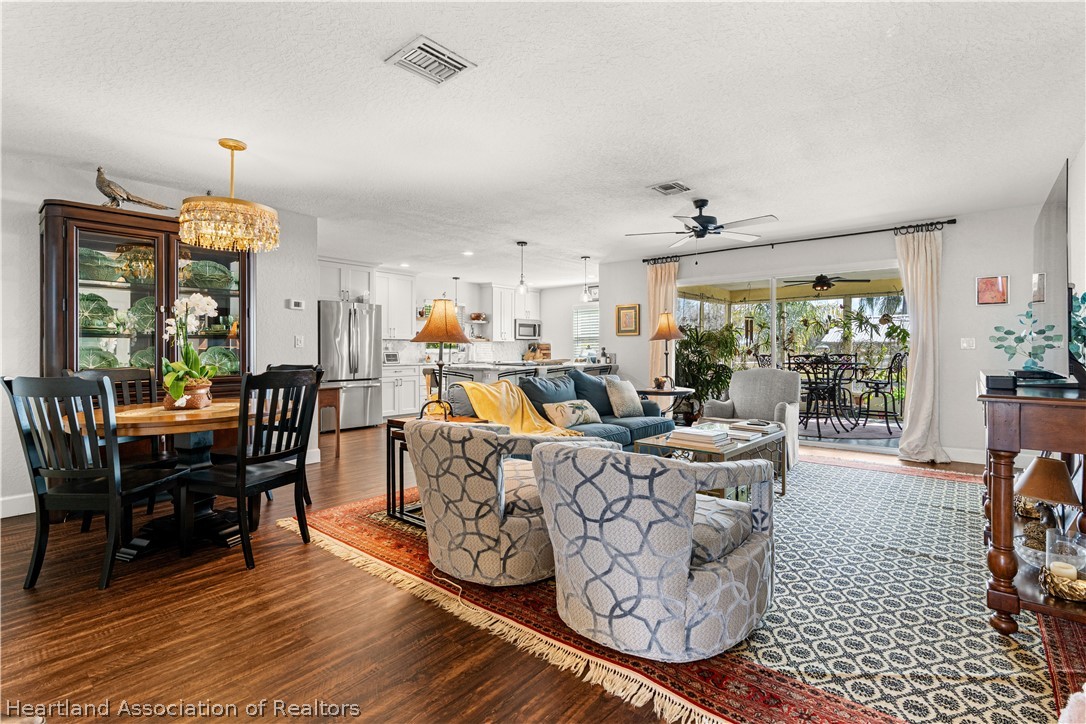 237 Wild Duck Point Lorida, FL 33857 - Photo 22 of 39 a living room with furniture a dining table and a floor to ceiling window