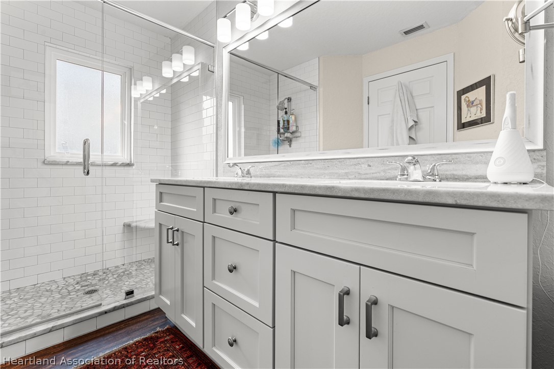 237 Wild Duck Point Lorida, FL 33857 - Photo 32 of 39 a bathroom with a double vanity sink a mirror a shower and vanity