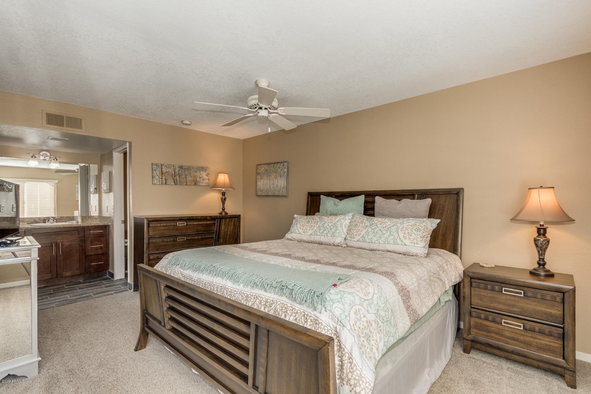 3600 North Hayden Road, Unit 2803 Scottsdale, AZ 85251 - Photo 15 of 22 a spacious bedroom with a bed and a chandelier
