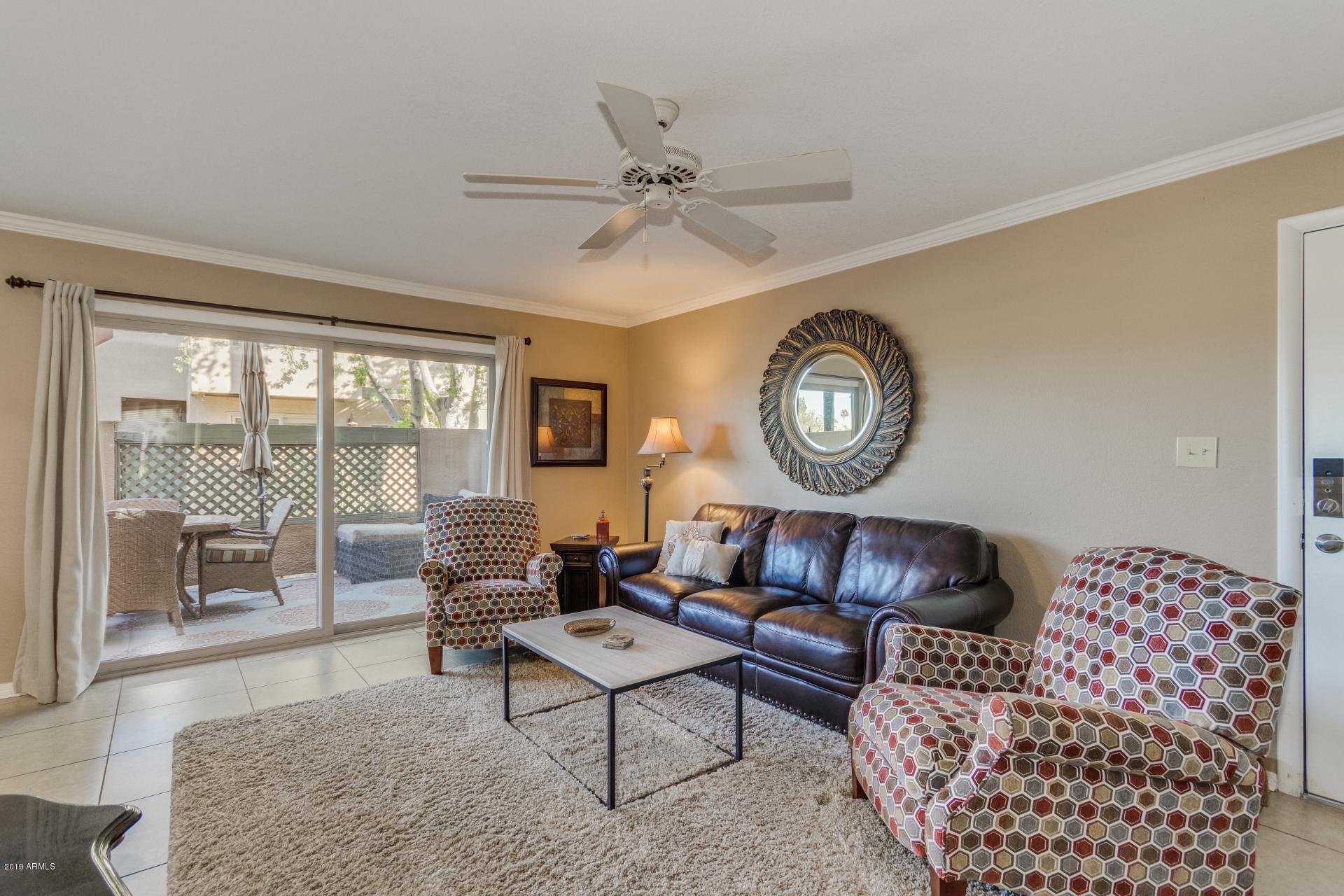 3600 North Hayden Road, Unit 2803 Scottsdale, AZ 85251 - Photo 4 of 22 a living room with furniture a clock and a large window