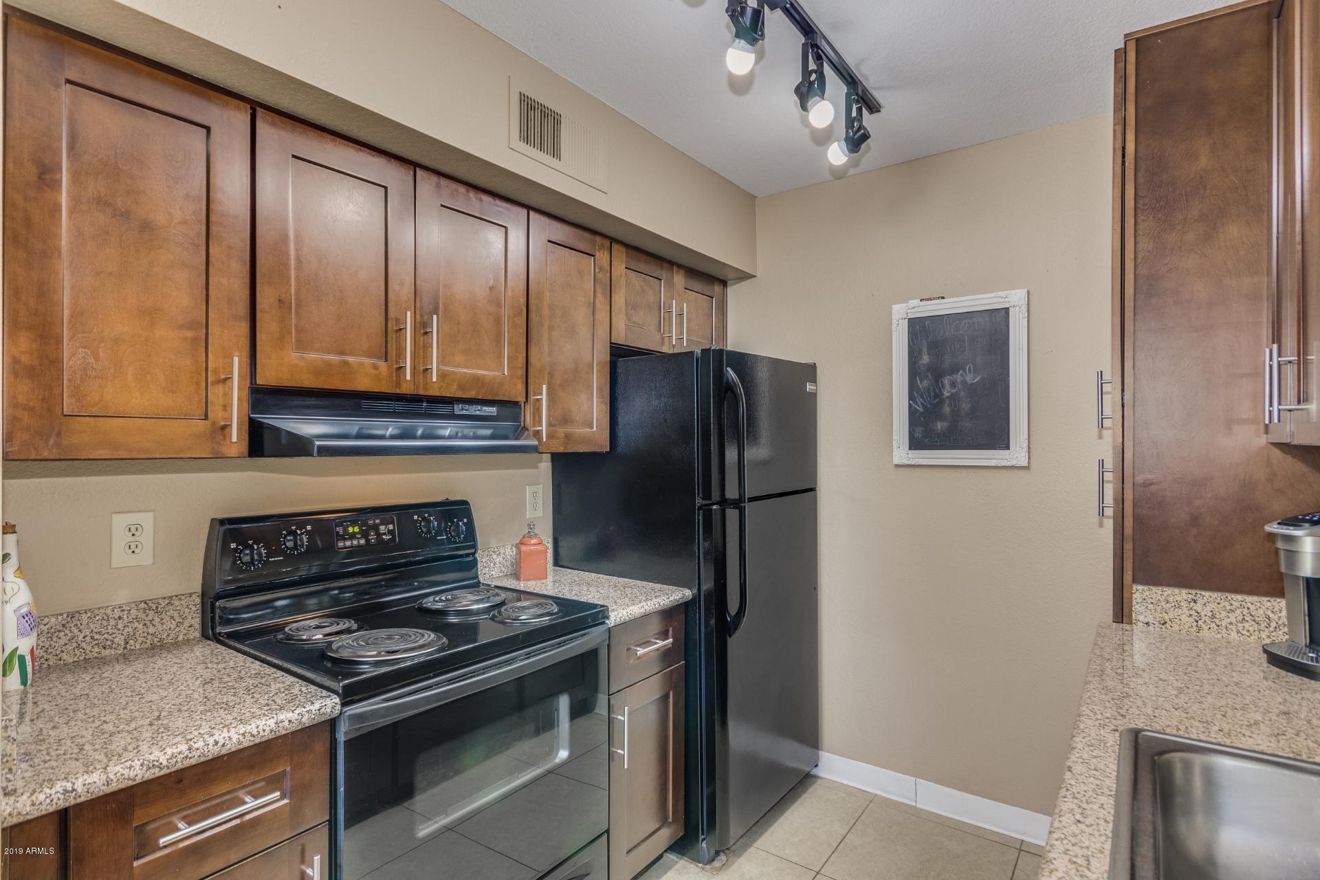 3600 North Hayden Road, Unit 2803 Scottsdale, AZ 85251 - Photo 7 of 22 a kitchen with stainless steel appliances granite countertop a stove refrigerator and a sink