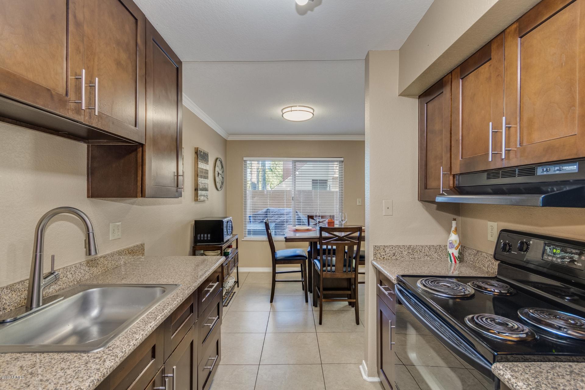 3600 North Hayden Road, Unit 2803 Scottsdale, AZ 85251 - Photo 9 of 22 a kitchen with granite countertop a stove a sink and a refrigerator