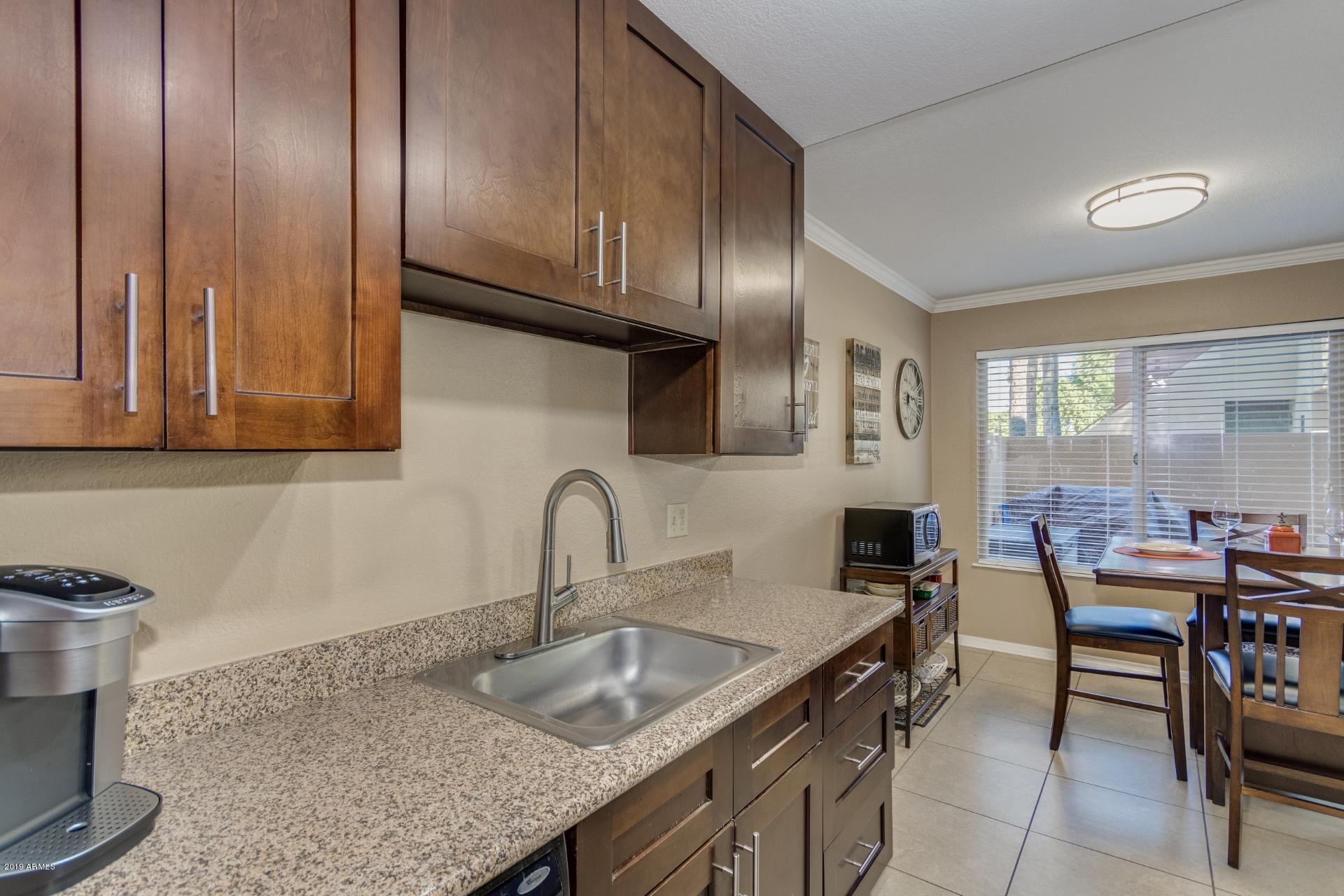 3600 North Hayden Road, Unit 2803 Scottsdale, AZ 85251 - Photo 10 of 22 a kitchen with granite countertop a sink a stove and wooden cabinets