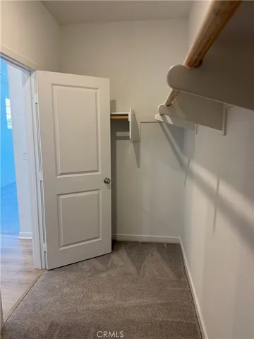 a view of walk in closet with empty racks