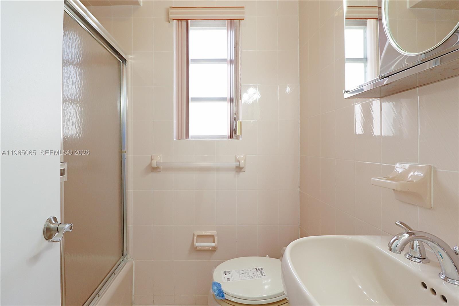 3330 Southwest 2nd Street Miami, FL 33135 - Photo 23 of 28 a bathroom with a sink a toilet and a mirror