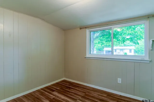 a view of a small space with wooden floor and a window