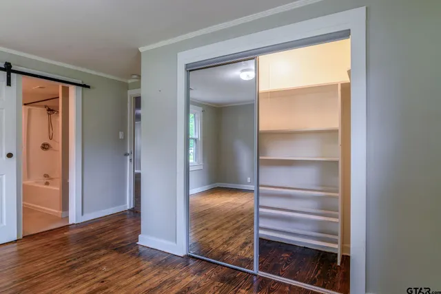 a view of walk in closet with wooden floor