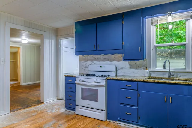 a kitchen with granite countertop wooden cabinets a sink and a window