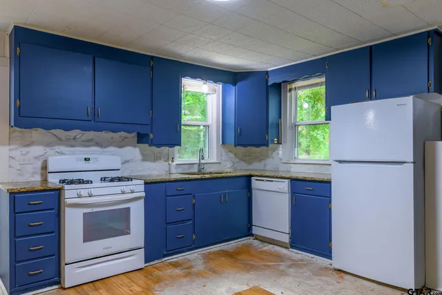 a kitchen with a refrigerator sink and cabinets