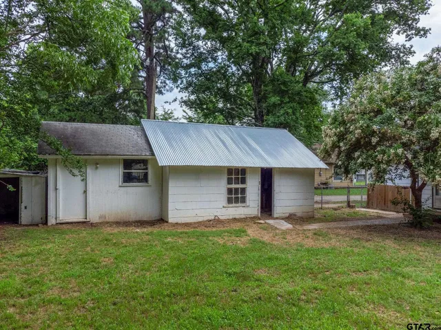 a backyard of a house with table and chairs