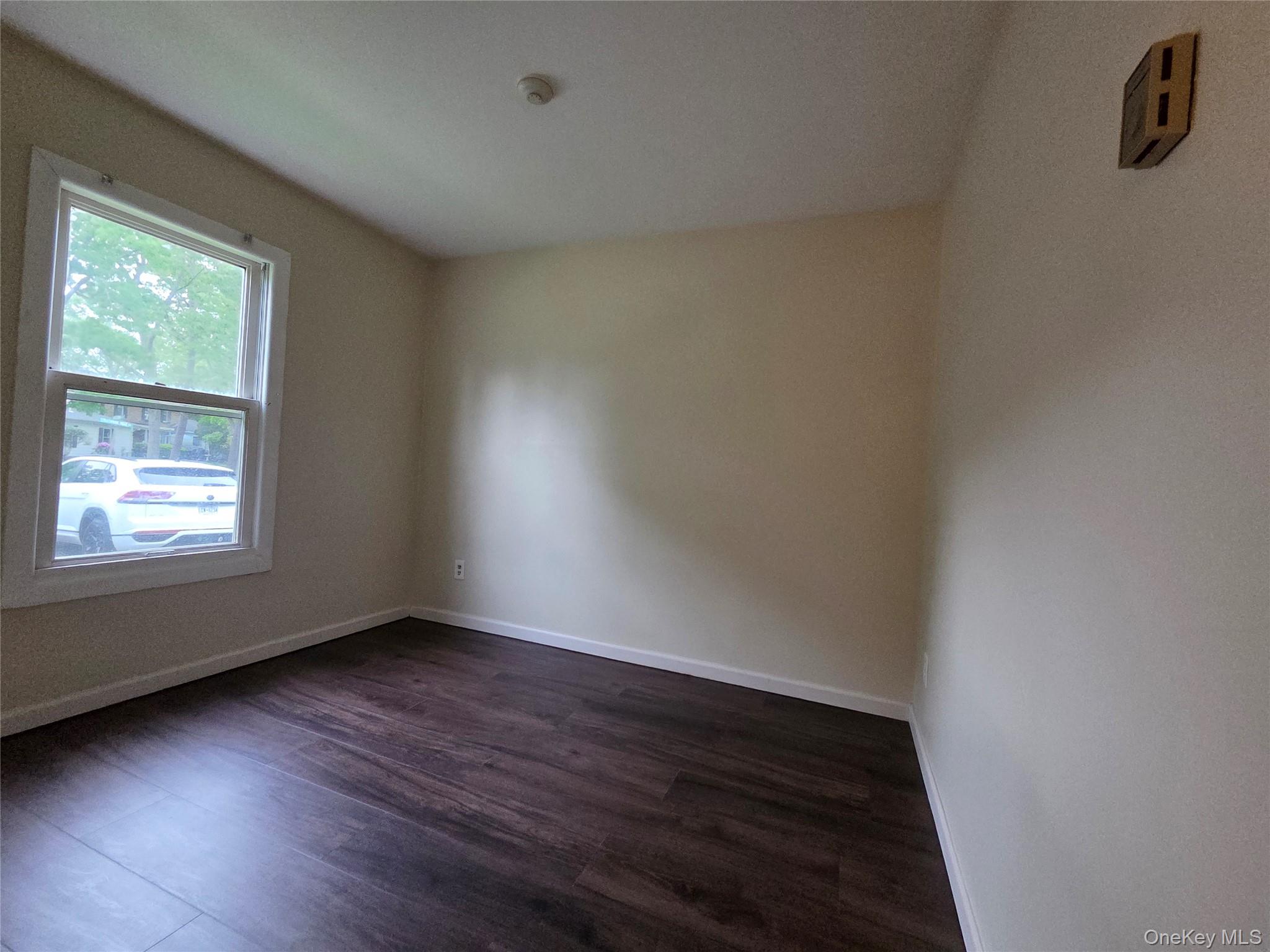 5 Independence Court, Unit 5A Ridge, NY 11961 - Photo 7 of 9 a view of an empty room with wooden floor and a window