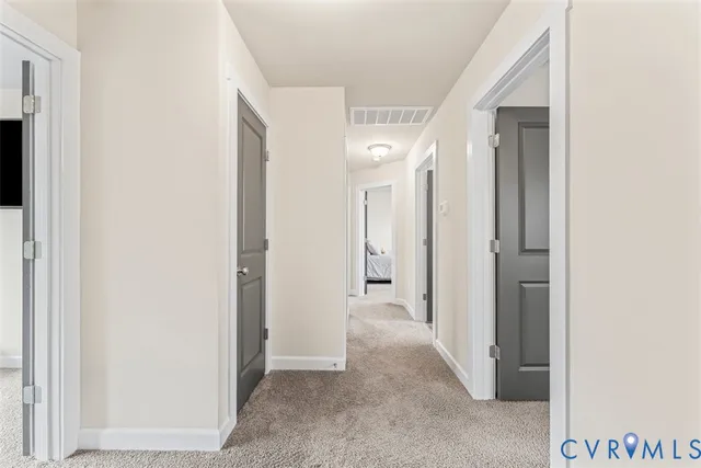 a view of a hallway with closet and mirror
