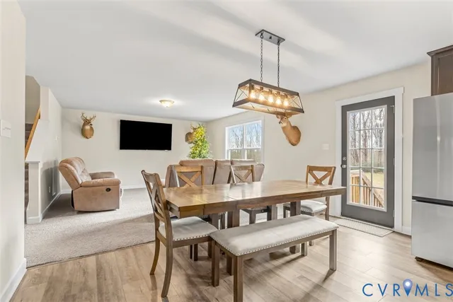 a dining room with furniture a chandelier and wooden floor