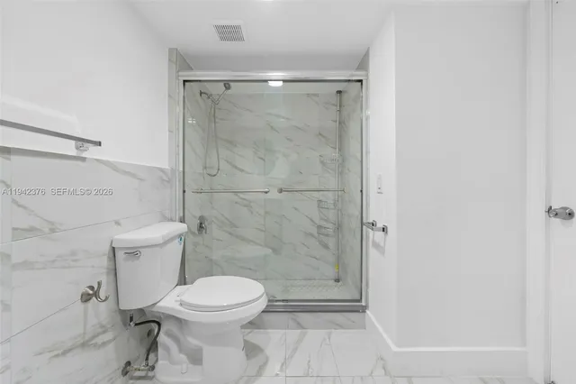 a bathroom with a toilet and a shower