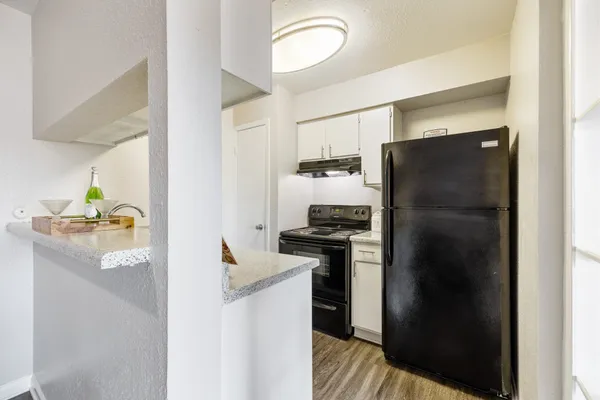 a kitchen with stainless steel appliances a refrigerator a stove a sink and a refrigerator
