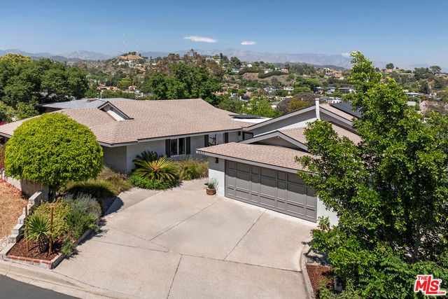 an aerial view of a house with garden space and street view