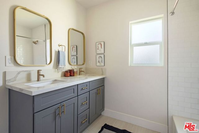 a bathroom with a double vanity sink and mirror