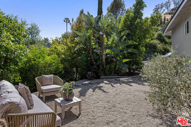 a view of backyard with a table and chairs and potted plants