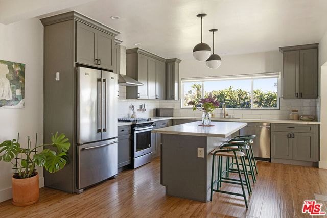 a kitchen with kitchen island white cabinets and stainless steel appliances