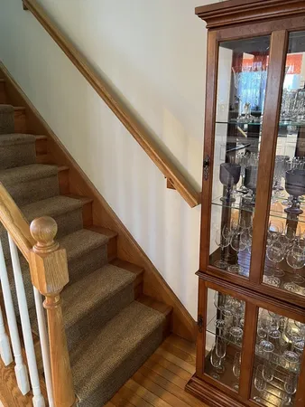a view of staircase with wooden floor and a rug