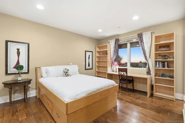 a bedroom with a bed and a large window