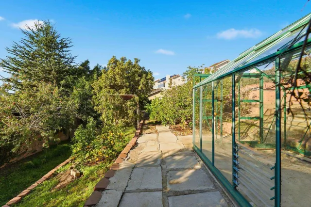 a view of house with garden and tall trees