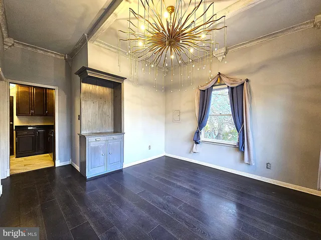 a view of a kitchen with furniture and stainless steel appliances