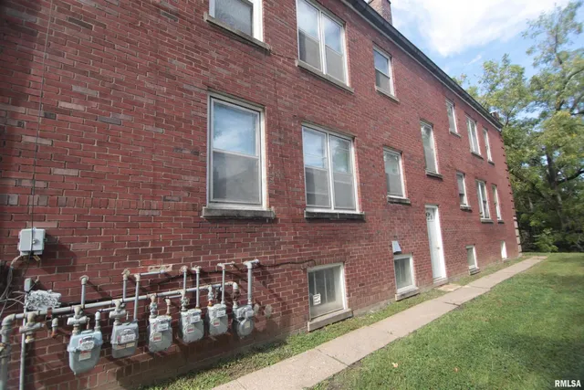 a view of a brick building next to a yard
