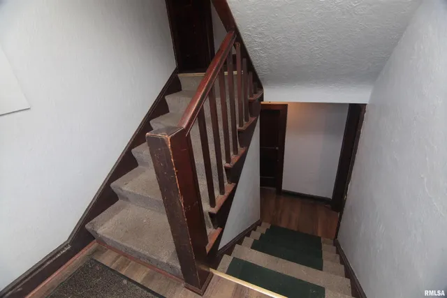a view of staircase with railing and a window