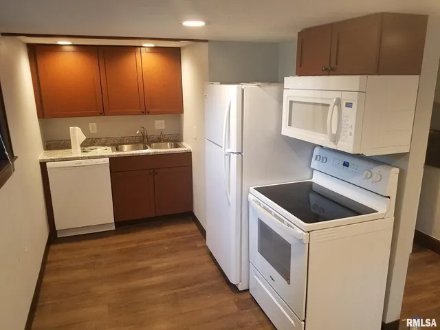 a room with a sink cabinets and washer dryer