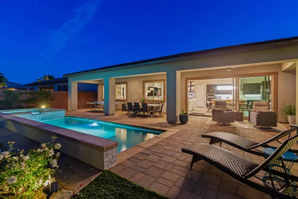 a view of a house with swimming pool and sitting area
