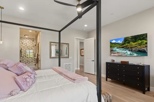 a bedroom with a bed and a flat screen tv