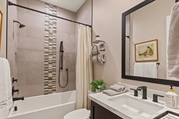 a bathroom with a granite countertop sink a toilet and a bathtub