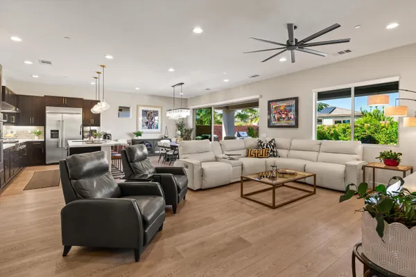 a living room with furniture kitchen view and a large window