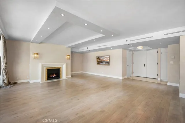 an empty room with windows and fireplace