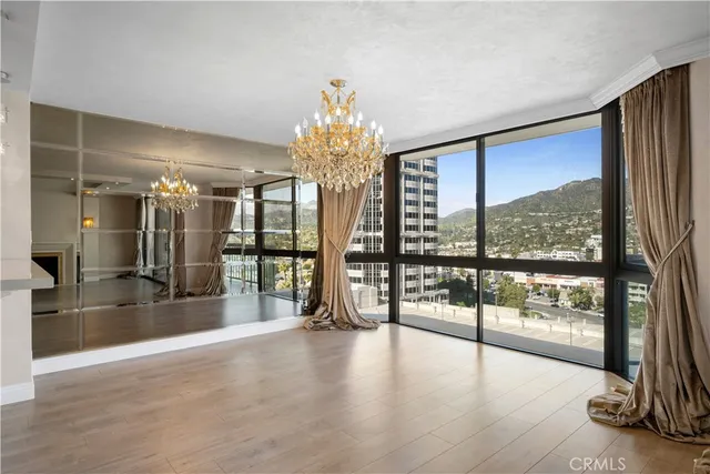 a view of a big room with floor to ceiling windows and a chandelier
