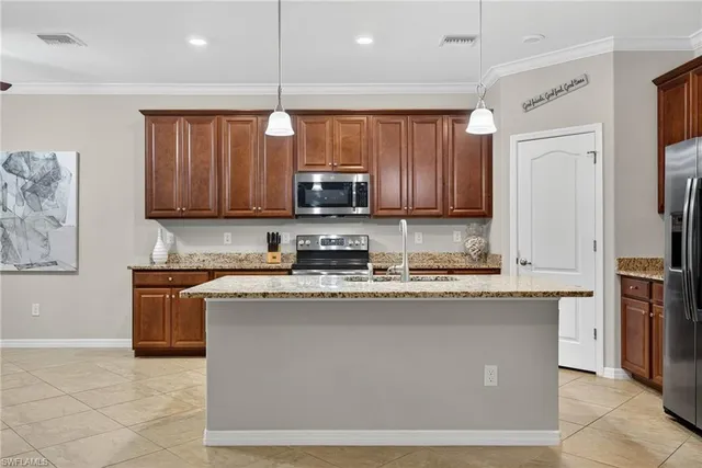 a kitchen with granite countertop stainless steel appliances microwave stove refrigerator and sink