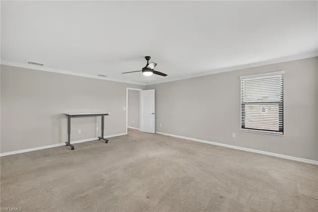 a view of an empty room with a chandelier fan