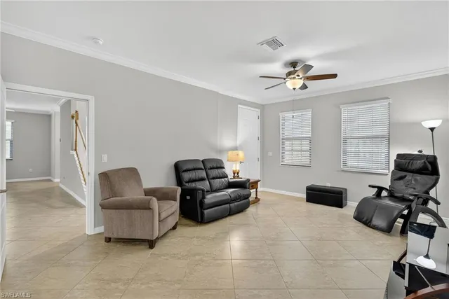 a living room with furniture a ceiling fan and a window