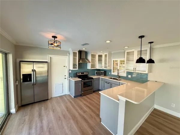 a kitchen with stainless steel appliances kitchen island a refrigerator sink and stove