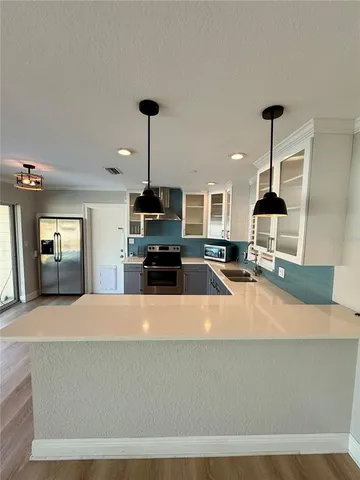a kitchen with stainless steel appliances a sink stove and refrigerator