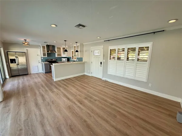 a view of a kitchen with kitchen island and stainless steel appliances