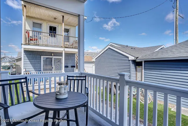 a view of a house with a deck and furniture