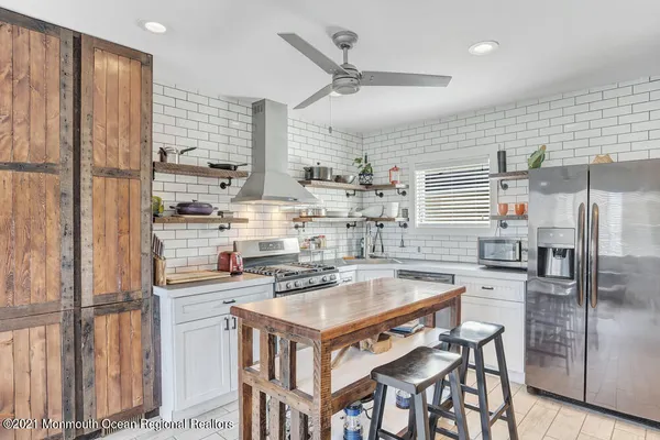 a kitchen with a stove a refrigerator and a table