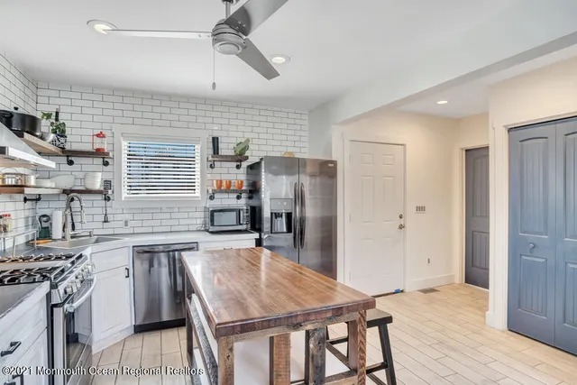 a kitchen with stainless steel appliances granite countertop a stove refrigerator and cabinets