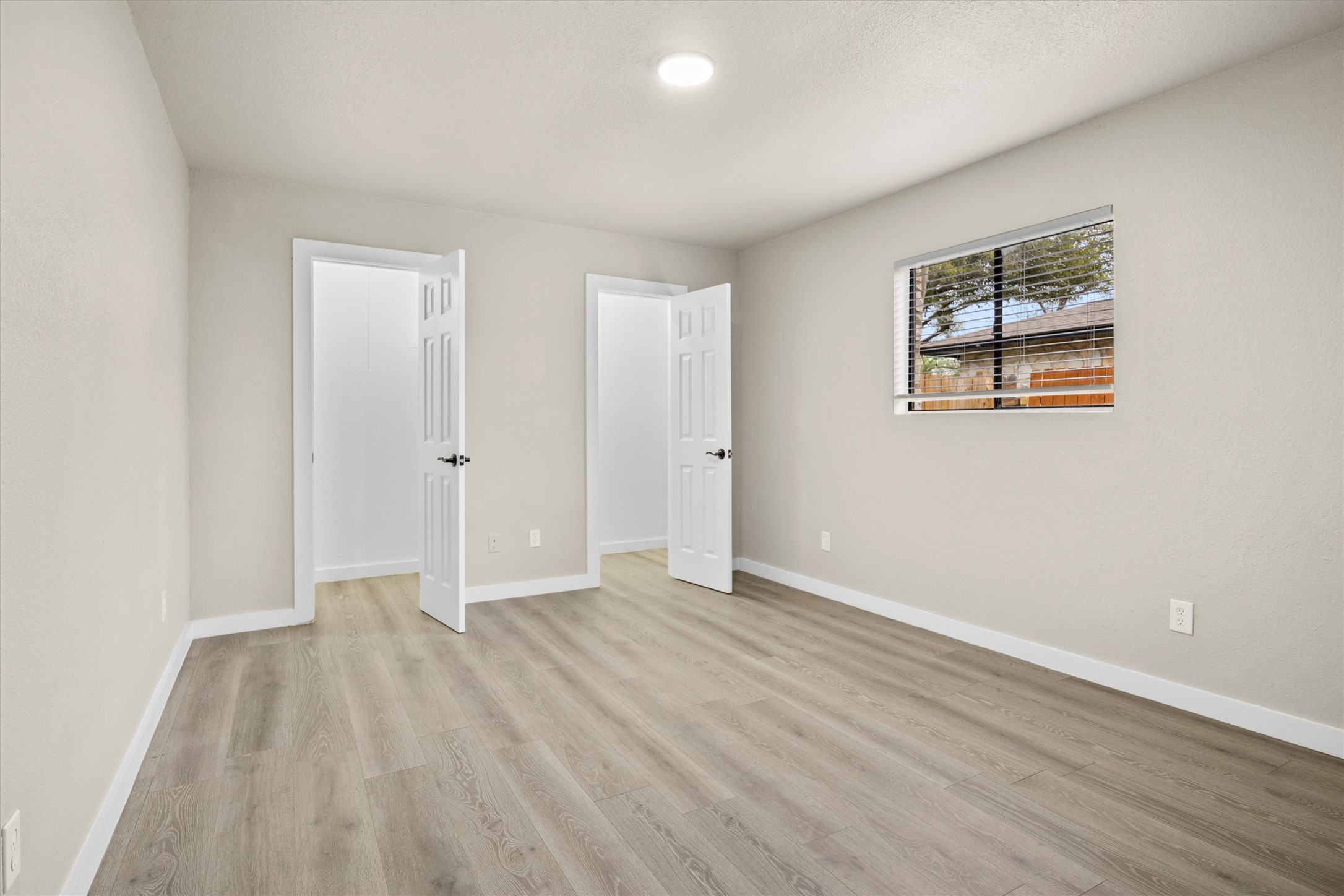 502 Pin Tail Lane Taylor, TX 76574 - Photo 13 of 26 Spacious room featuring wood-finish flooring, light neutral wall tones, white trim, and a window with horizontal blinds