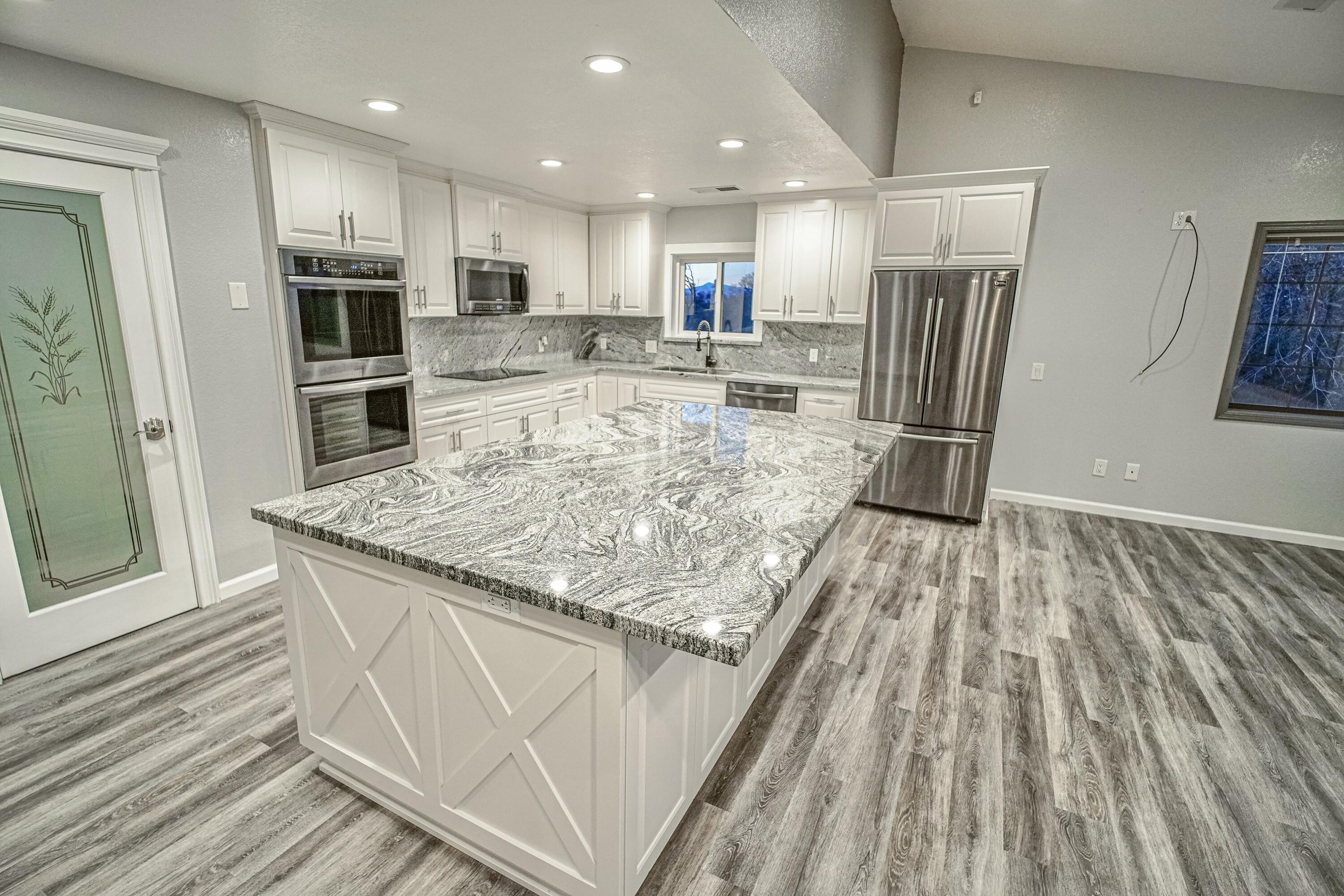 16785 Billy Lane Red Bluff, CA 96080 - Photo 11 of 69 a kitchen with stainless steel appliances granite countertop a refrigerator oven a sink and dishwasher with wooden floor