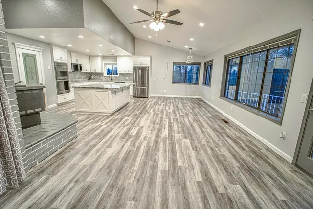 a view of kitchen with cabinets stainless steel appliances and a window