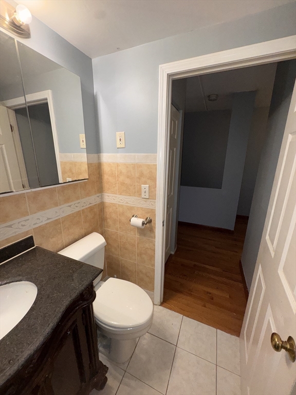 100 Lawn Street, Unit 100 Boston, MA 02120 - Photo 15 of 40 a bathroom with a granite countertop sink toilet and mirror